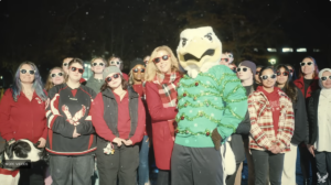 Screenshot of EWU's award-winning holiday video. Picture is a crowd shot with President McMahan, Swoop in a holiday sweater and a big group of students.